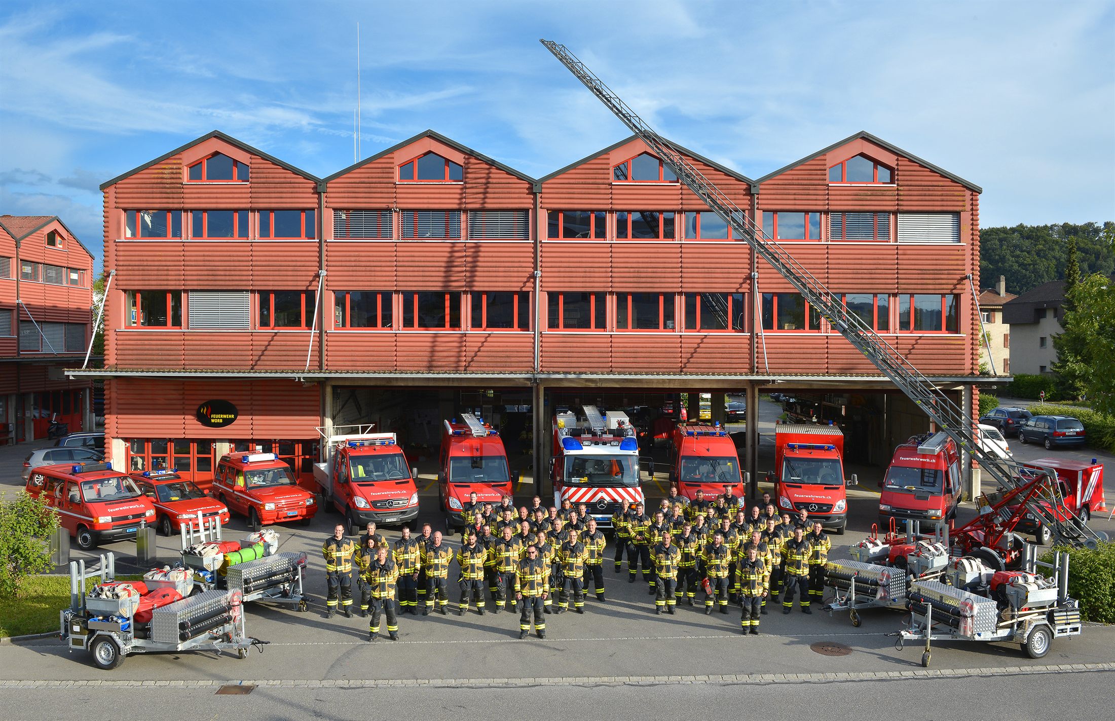 Die Feuerwehr Worb mit der gesamten Fahrzeugflotte vor dem Magazin Worb